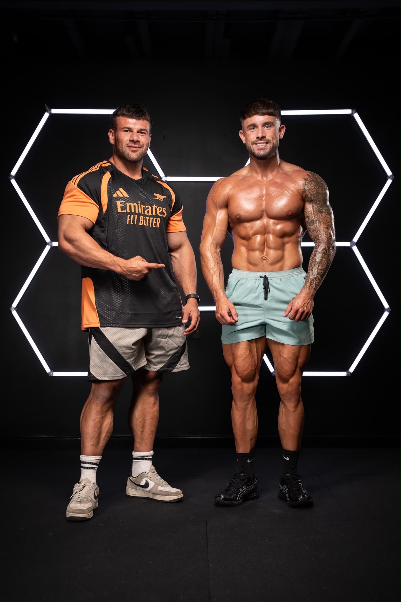 Joey Farrell, on the left, with his client Jarrod in a gym lit by hexagonal lights.