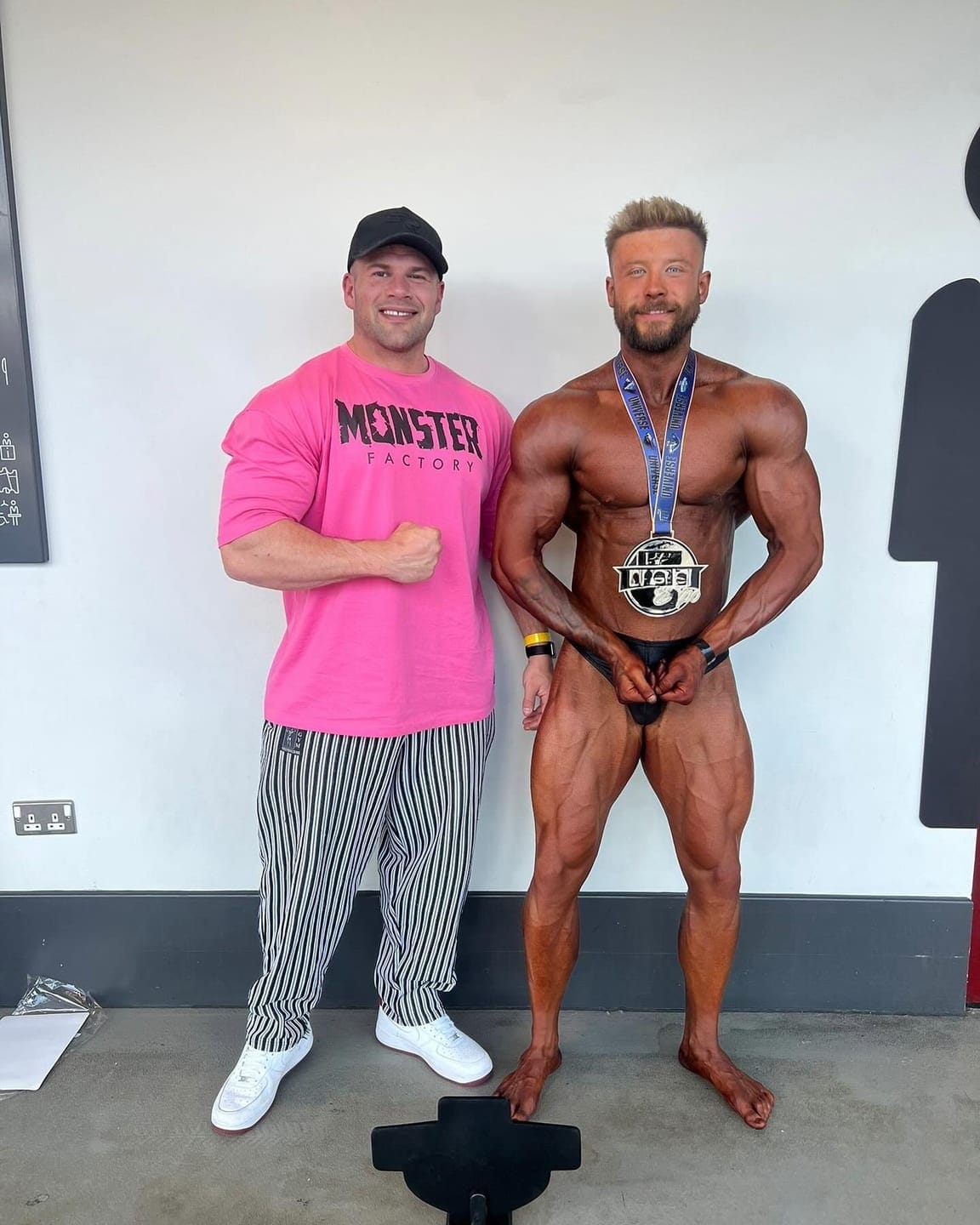 A ProFlow Physiques client wearing the medal they won, photographed just after coming off stage.